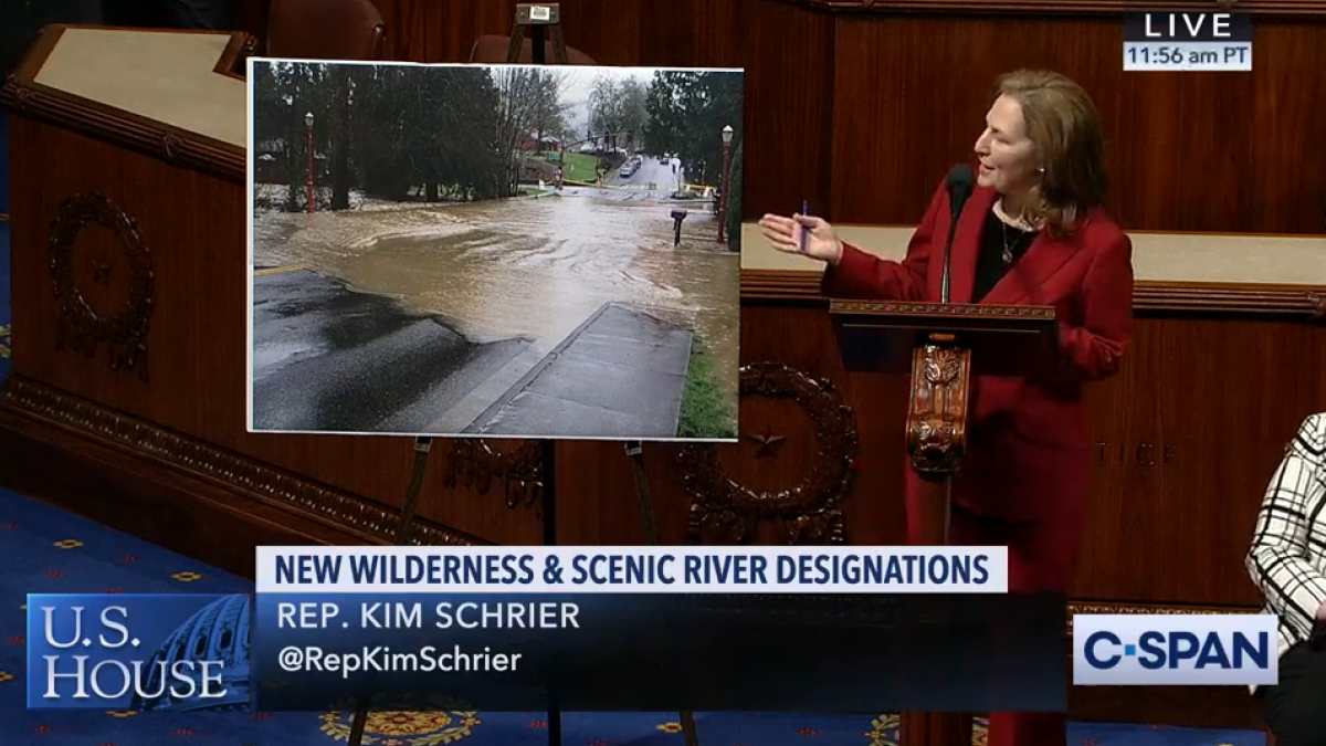 Rep. Schrier with photo of flooding in Issaquah