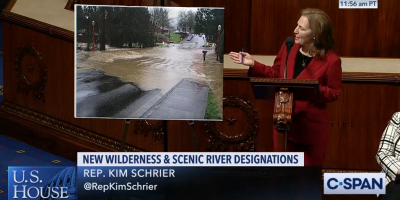 Rep. Schrier with photo of flooding in Issaquah