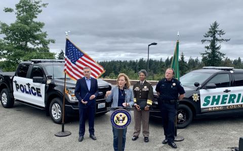 Rep. Schrier in front of two police cars