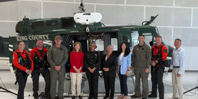 Congresswoman Schrier, local leaders in front of a King County Sheriff's Office rescue helicopter